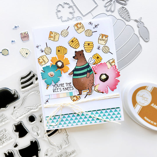 “You’re the bee’s knees” card with beehives, honey pots, swirling bees with a bear accented with flowers and triangle paper.
