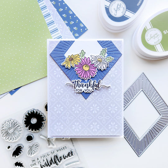 A card with the sentiment "Thankful for you," featuring a delicate floral-patterned paper arranged with daisies in a diamond shape.