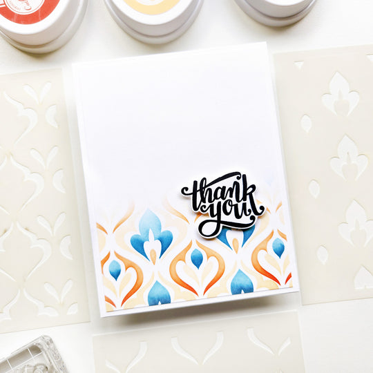 Thank you card with colorful stenciled design on a textured surface