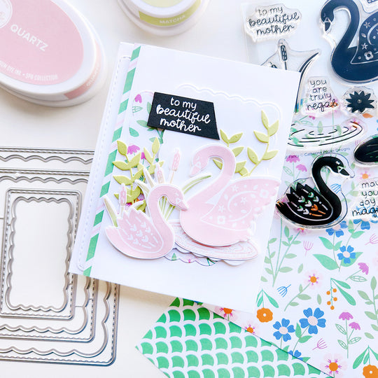 "To my beautiful mom" sentiment card featuring two pink swans on a rippled pond, with floral-patterned paper, green vines, and cattails.
