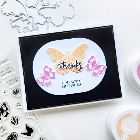 Butterfly designs card with 'thanks' message, surrounded by stamping tools on a white background