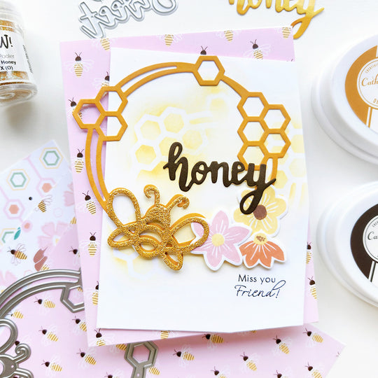 "Miss You Friend" card with a honeycomb wreath, floral and bee accents, and a "honey" word die atop bee-patterned paper.