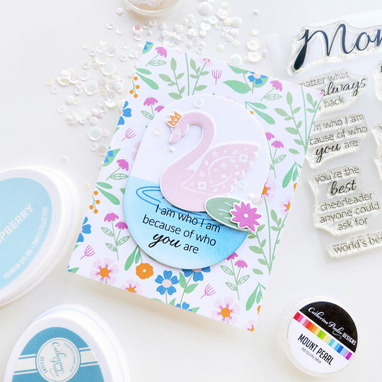 "I am who I am because of you" card with a pink swan on a pond with a lily pad, set against floral-patterned paper and sequin accent.