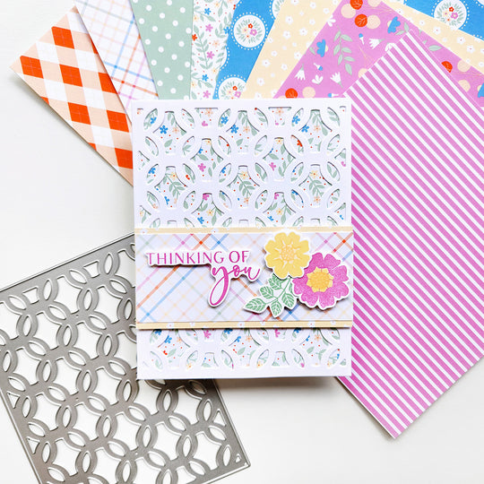 Colorful patterned paper with a 'Thinking of you' card and decorative elements on a white background.