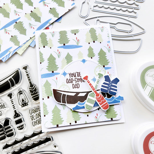 "You're Oar-some Dad" sentiment pops on tree-patterned paper with a canoe, paddles, and life vest.