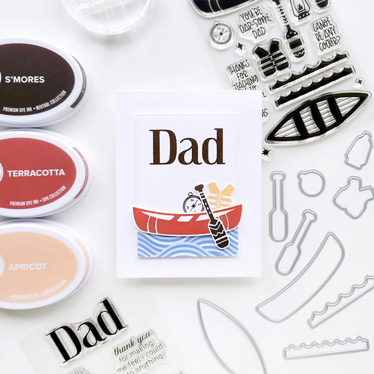 Dad card featuring a canoe surrounded by a life vest, compass and paddle, floating on wave-inspired patterned paper.