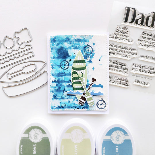 A card for Dad featuring a canoe with paddles and a compass, all set against a soft watercolor background.