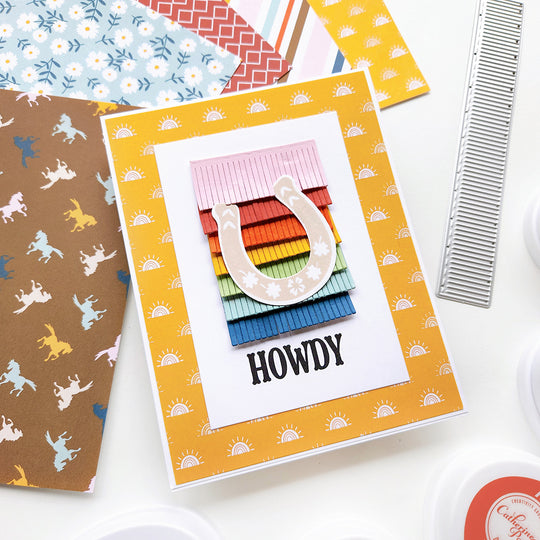A rainbow fringe, a floral horseshoe, and a "Howdy" sentiment, all crafted using Sunrise patterned paper for a southwestern feel.