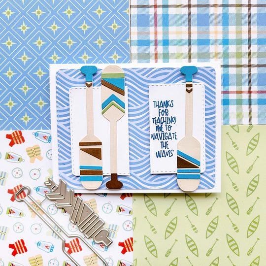 A card with the sentiment “Thanks for teaching me to navigate the waves,” set on wave-inspired paper and decorative paddles.