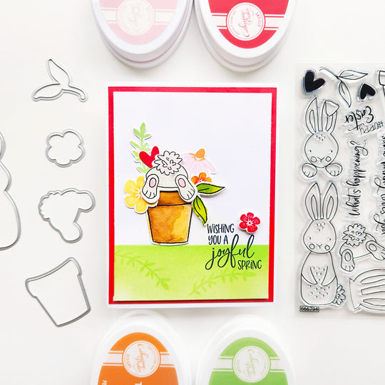 Wishing you a joyful spring! This charming card features a bunny upside down in a pot of colorful flowers.
