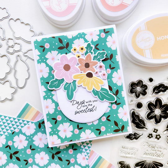 “Days with you are the sweetest” card showcasing a cluster of flowers of different sizes set upon floral-patterned paper.