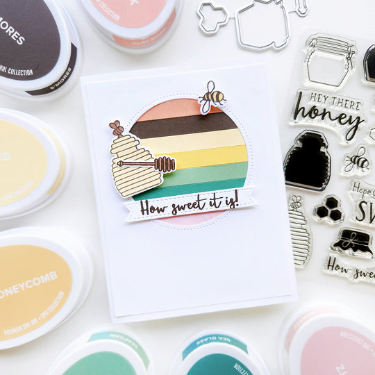 "How Sweet It Is" card with a bee and honey jar atop colorful striped paper.