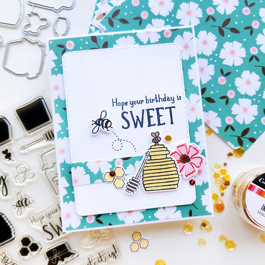 "Hope Your Birthday Is Sweet" card featuring a honey jar, bee, flower, and sequins atop floral-patterned paper.