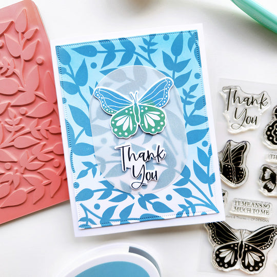 Card with butterfly design and 'Thank You' text, surrounded by stamping tools on a white background