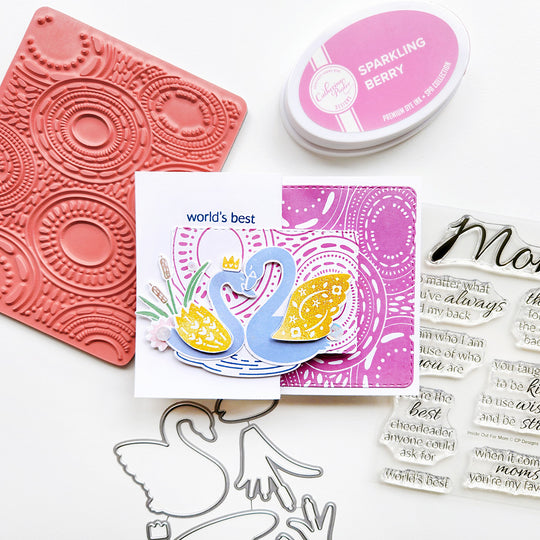 World's best mom card with two light blue swans with gold wings on a berry pink rippled background.