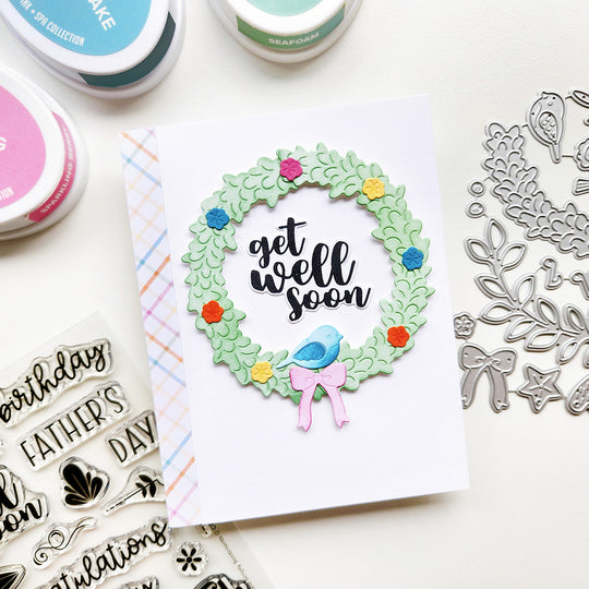 Card with 'get well soon' wreath design with a blue bird and pink bow