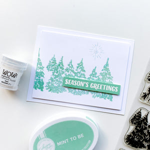 Season's greetings card with evergreen woods stamp