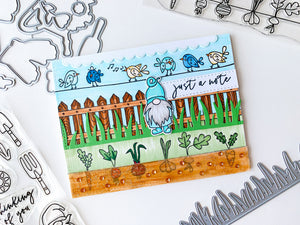 Gnome scene with picket fence, singing birds and planted veggies