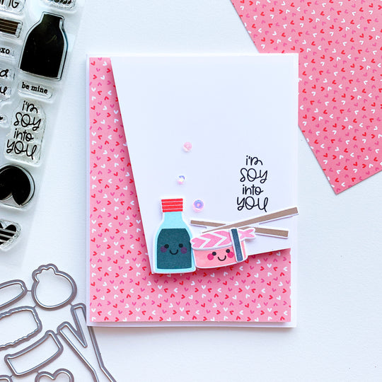 Sushi cutout pieces over pink heart paper