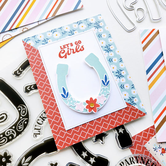  A floral horseshoe and "Let's Go Girls" sentiment, crafted with Howdy patterned paper for a fun, rustic touch. 