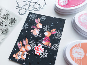 Skiing Bunnies with snow on a black card