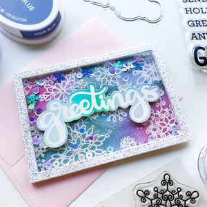 card with greetings sentiment and scrolling snowflakes stamps
