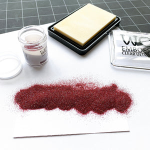 embossing glitter spilled on paper and embossing ink pad