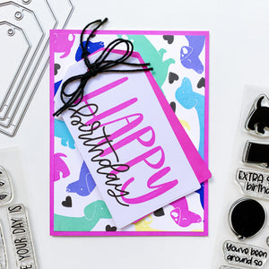 Big Happy stamp on tag with multicolored doxie background
