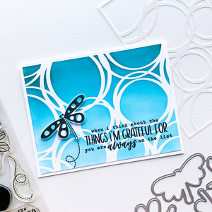 card with scribbled circles background and dragonflies