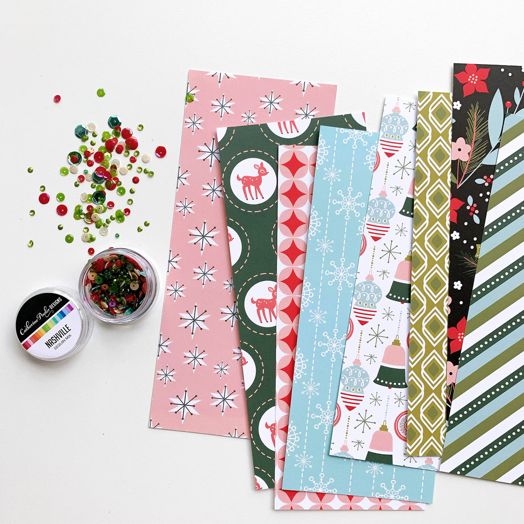Grandma's Attic Slimline Patterned Paper fanned out next to nashville sequins