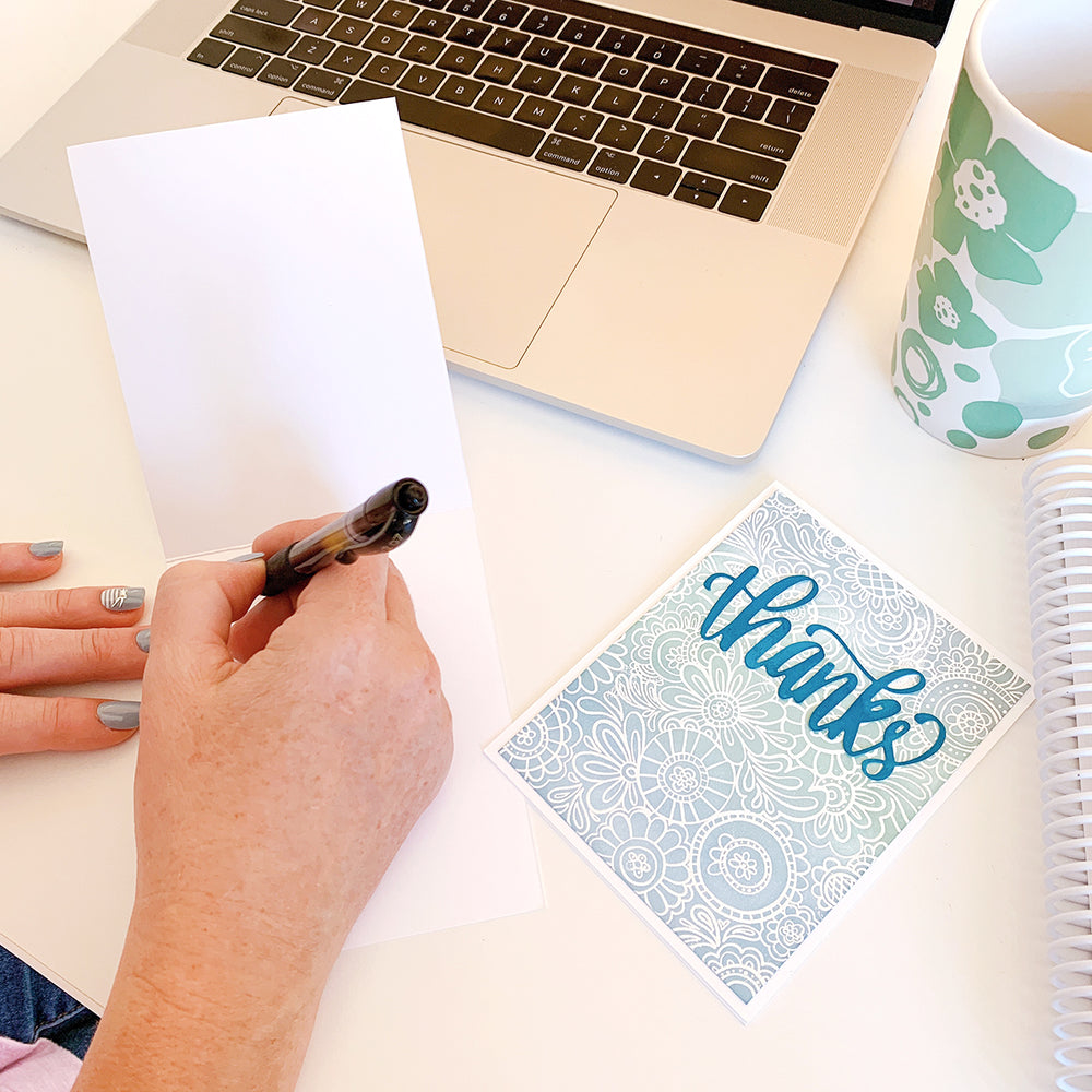 person writing in a thank you card