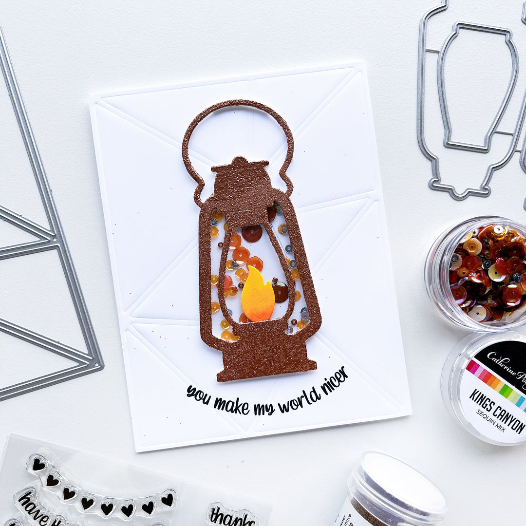 Nicer card using Camping Lantern die, Capture the Flag cover plate die, Round About Messages Stamp set and Kings Canyon sequin mix.