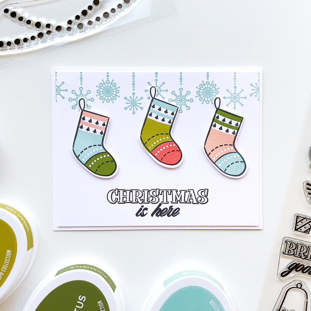 christmas is here with stockings on garland border