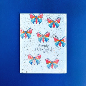 Colored origami butterflies with speckled background card