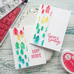 Two holiday cards with colorful pine trees